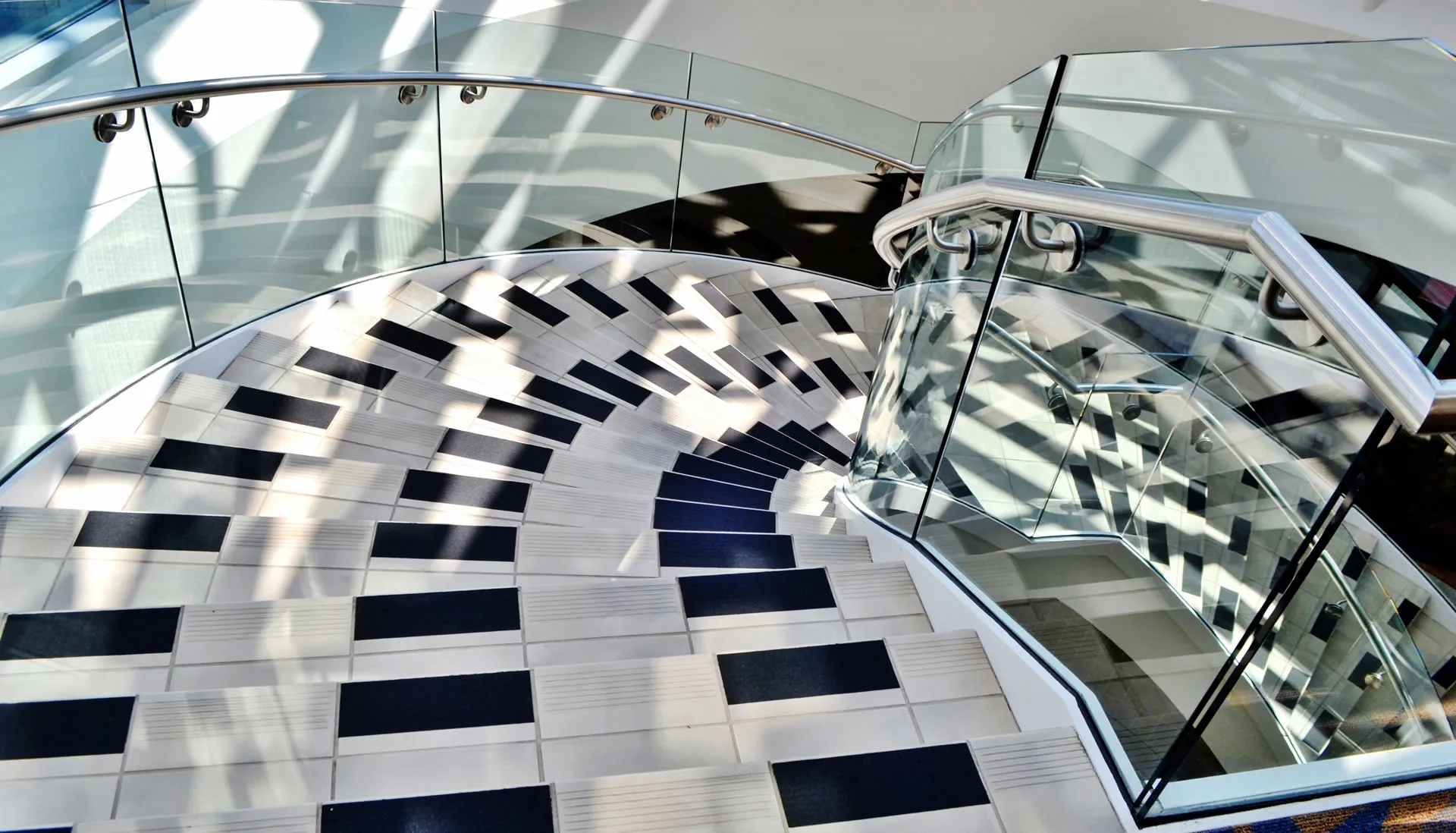 a staircase with a glass railing and a metal handrail